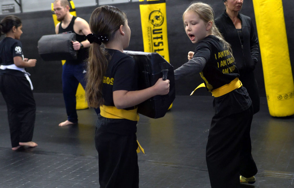 girl practicing punches in martial arts class