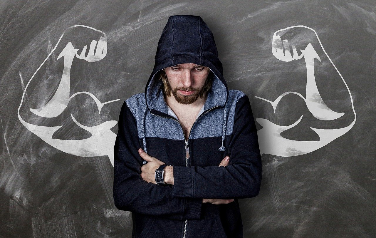 A man in a hoodie with muscley arms drawn behind him