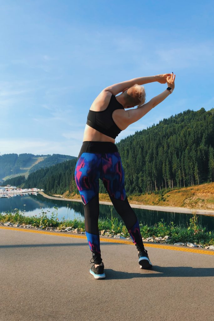 woman stretching on roadside before a run